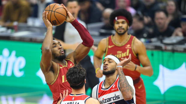 Jan 3, 2024; Cleveland, Ohio, USA; Cleveland Cavaliers guard Donovan Mitchell (45) shoots between Washington Wizards forward Deni Avdija (8) and center Daniel Gafford (21) in the first quarter at Rocket Mortgage FieldHouse. Mandatory Credit: David Richard-USA TODAY Sports